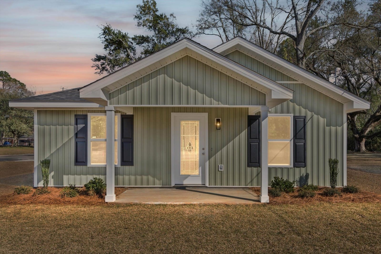 Beautiful new construction home exterior at golden hour with warm sunlight and blue sky